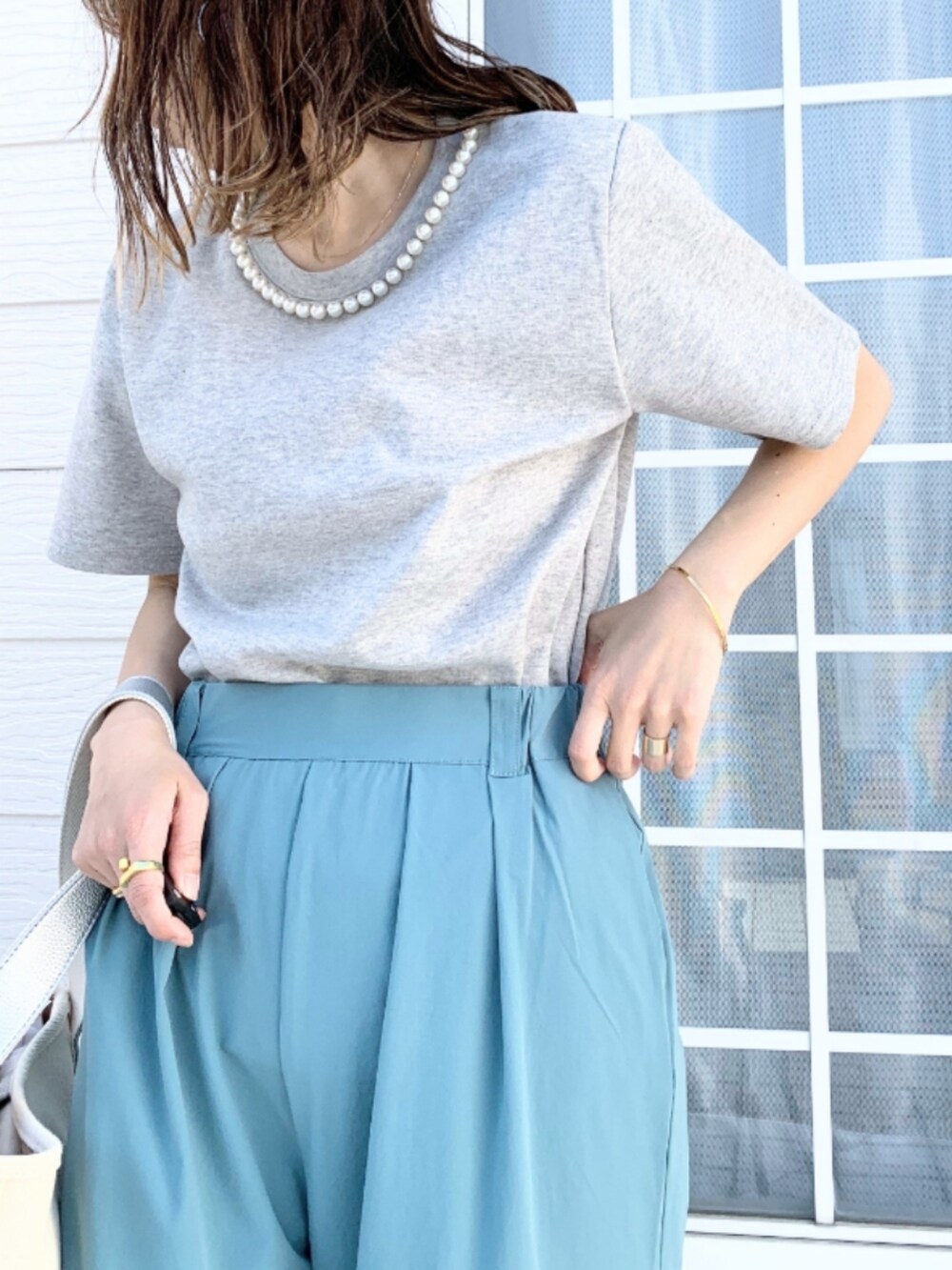 ブルー系のその他パンツ、シルバー系のハンドバッグ、グレー系のTシャツ/カットソーを着用したレディースの春コーディネートの3枚目の写真