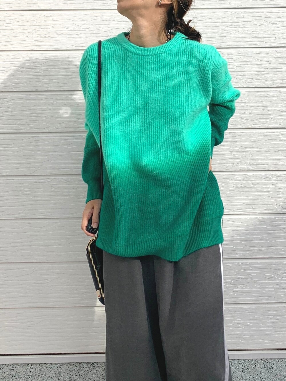 グリーン系のニット/セーター、グレー系のその他パンツ、シルバー系のスニーカーを着用したレディースの冬コーディネートの3枚目の写真