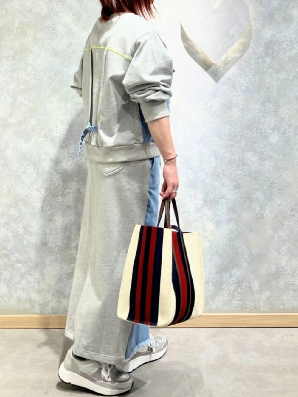 ブルー系のスカート、ブルー系のスウェット、シルバー系のスニーカーを着用したレディースの冬コーディネートの3枚目の写真