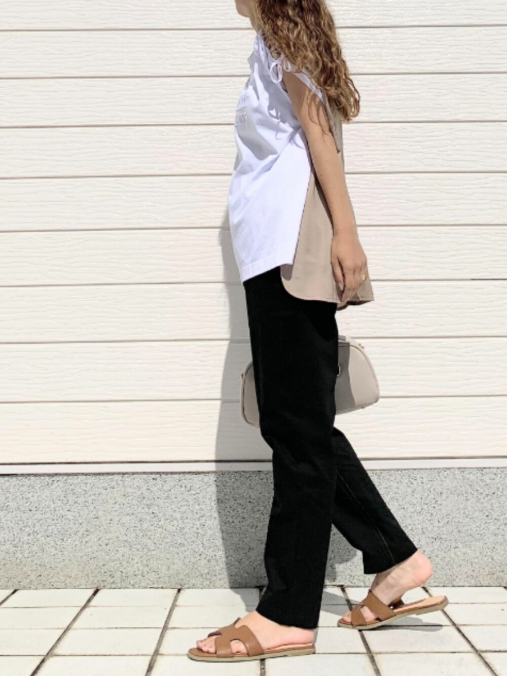 ブラック系のその他パンツ、イエロー系のサンダル、ホワイト系のボストンバッグを着用したレディースの夏コーディネートの2枚目の写真