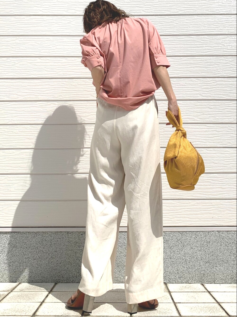 ピンク系のシャツ/ブラウス、イエロー系のショルダーバッグ、ブラウン系のサンダルを着用したレディースの春コーディネートの3枚目の写真