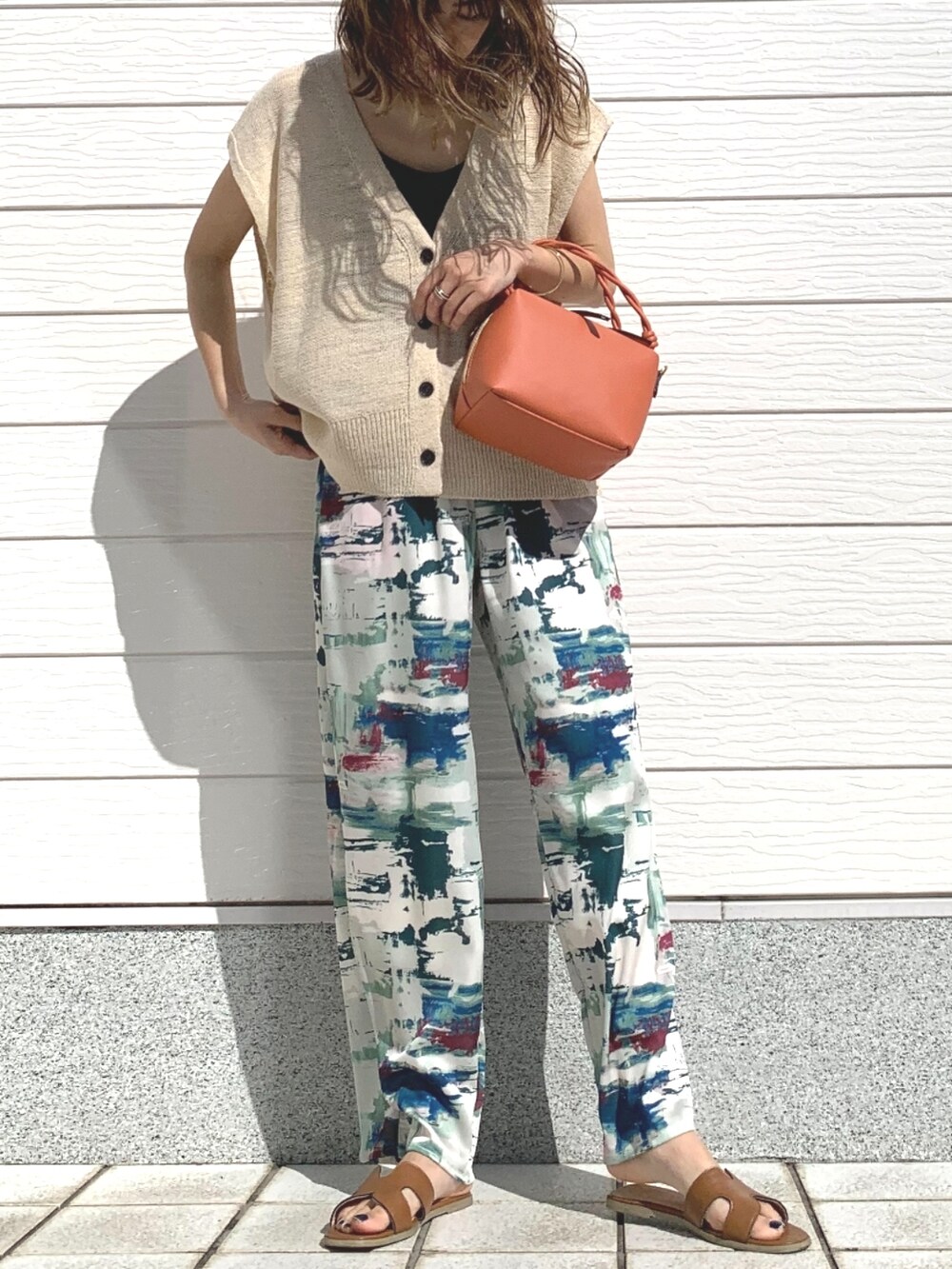 グリーン系のその他パンツ、イエロー系のサンダル、ホワイト系のベストを着用したレディースの春コーディネートの3枚目の写真