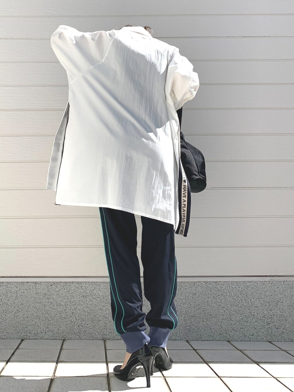 ブラック系のショルダーバッグ、ホワイト系のシャツ/ブラウス、ブルー系のその他パンツを着用したレディースの冬コーディネートの3枚目の写真