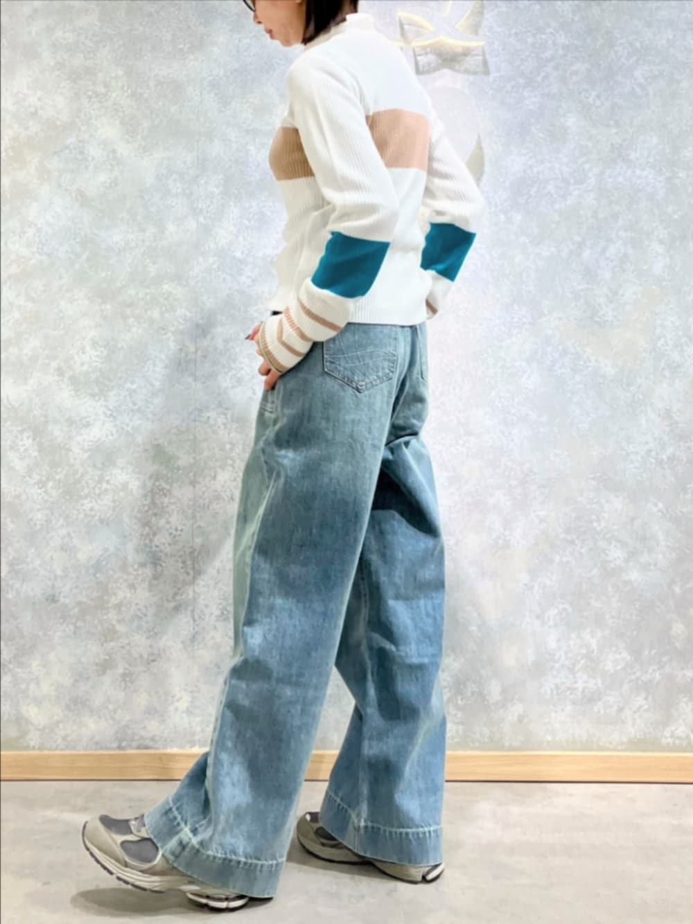 ブルー系のデニムパンツ、ホワイト系のニット/セーターを着用したレディースの冬コーディネートの3枚目の写真