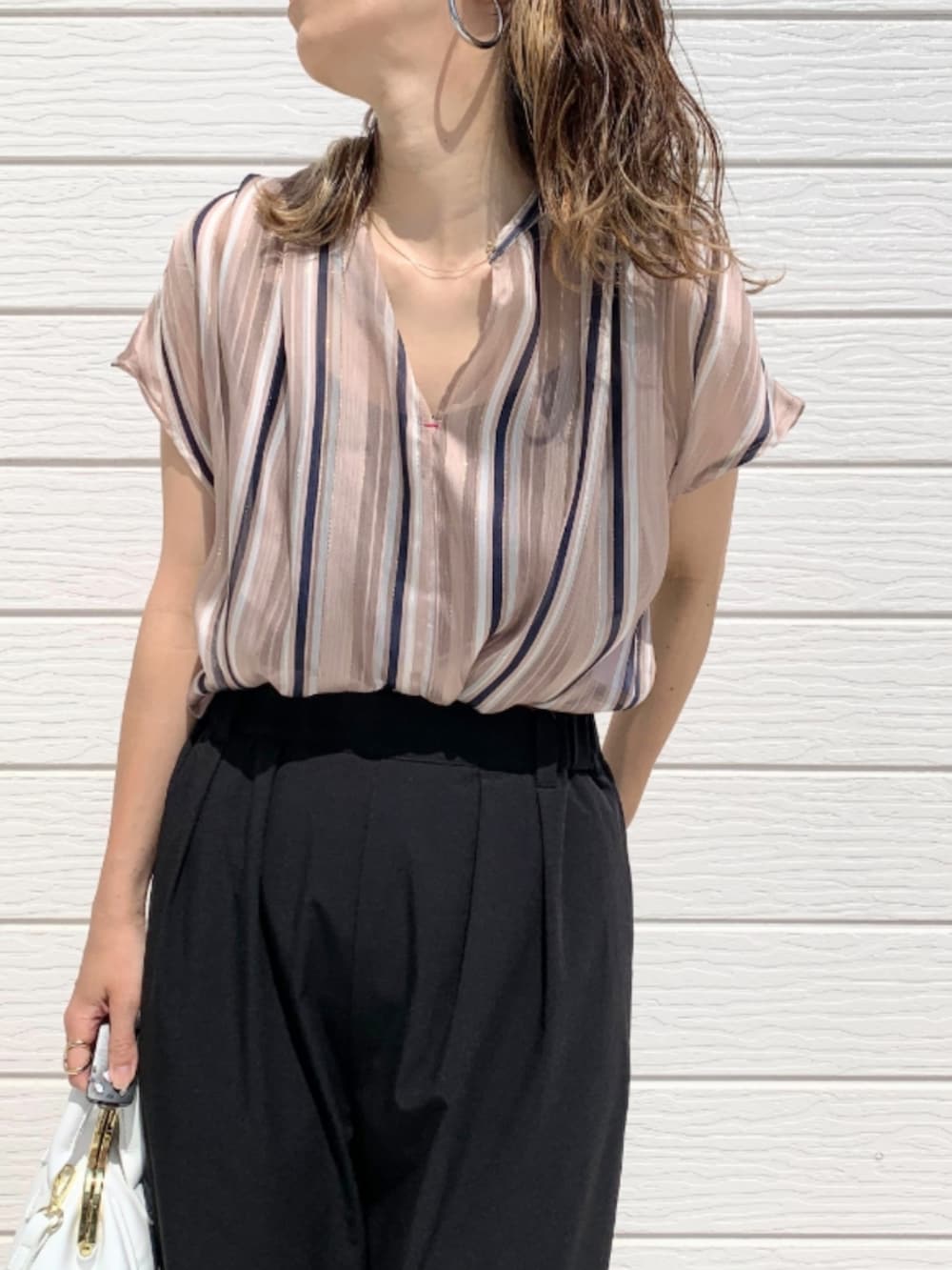 ホワイト系のショルダーバッグ、ブラック系のその他パンツ、ブラウン系のサンダルを着用したレディースの春コーディネートの4枚目の写真