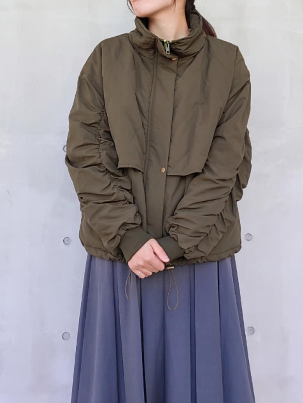 ホワイト系のスニーカー、グリーン系のミリタリージャケット、ホワイト系のTシャツ/カットソーを着用したレディースの秋コーディネートの2枚目の写真