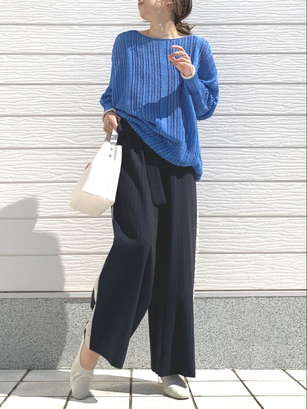 ホワイト系のハンドバッグ、ブルー系のその他パンツ、ブルー系のニット/セーターを着用したレディースの春コーディネートの3枚目の写真