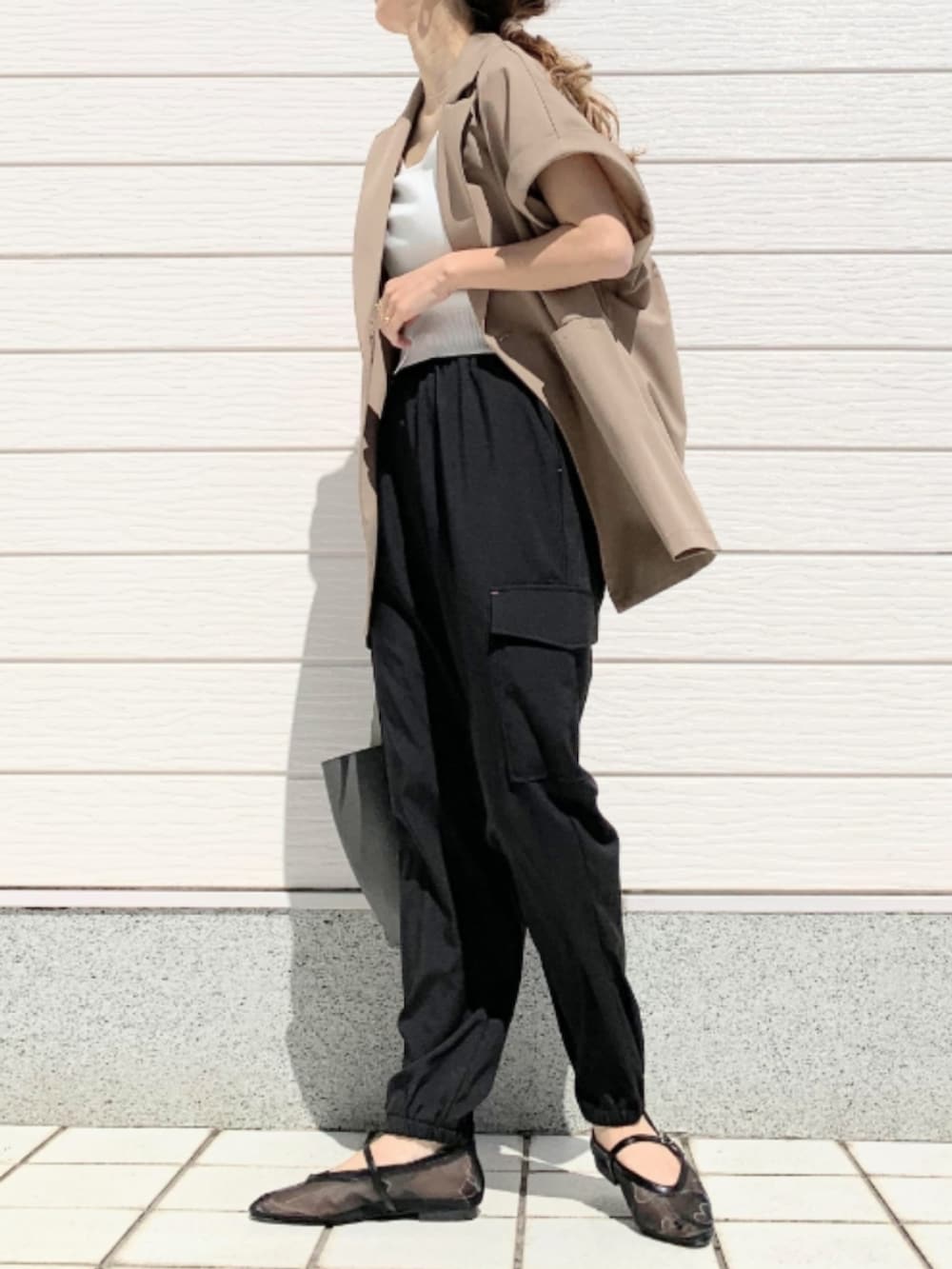 ブラック系のパンプス、ブラック系のカーゴパンツ、ベージュ系のテーラードジャケットを着用したレディースの春コーディネートの2枚目の写真