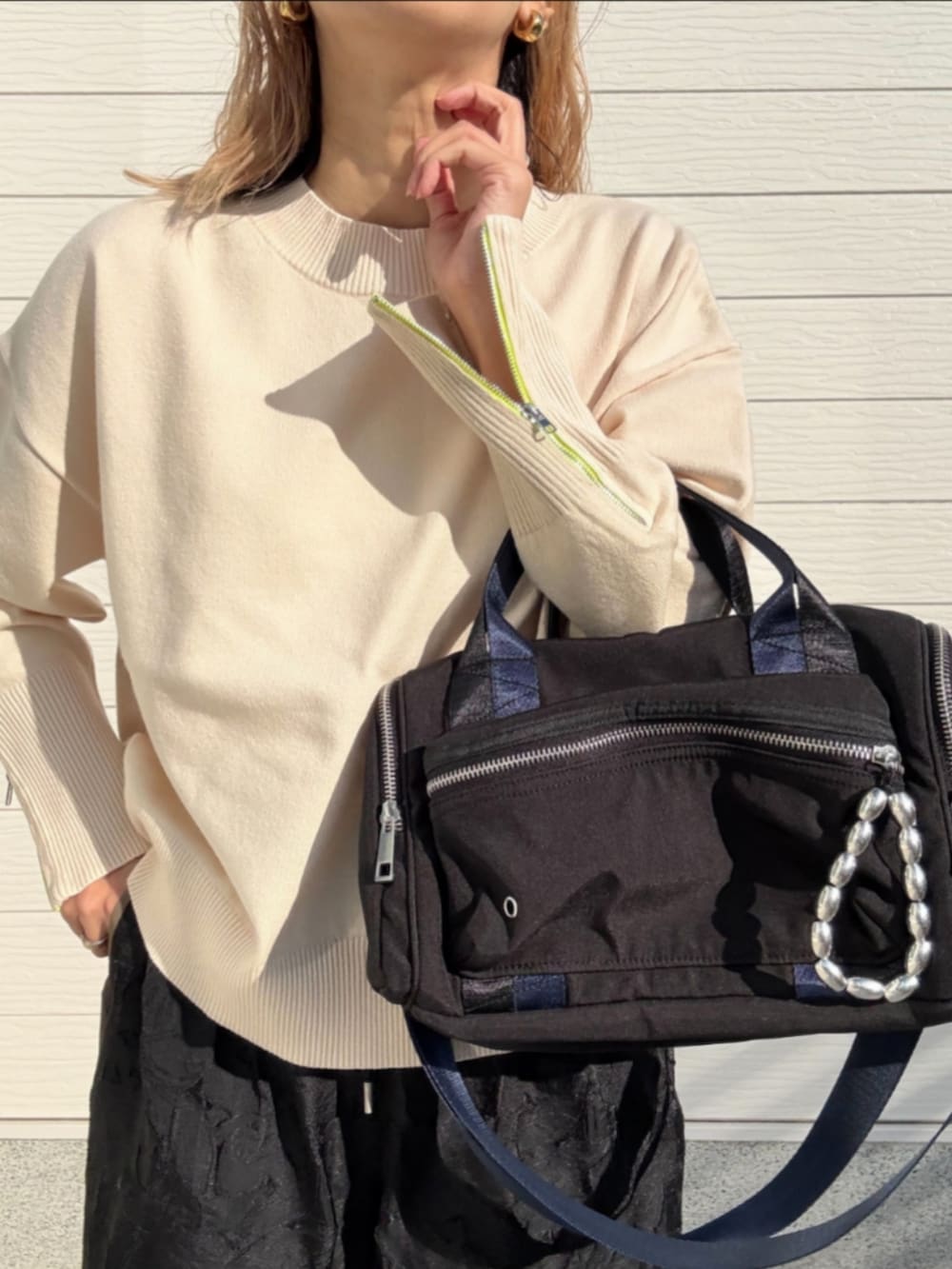 ホワイト系のニット/セーター、ブラック系のボストンバッグ、ブラック系のその他パンツを着用したレディースの冬コーディネートの4枚目の写真