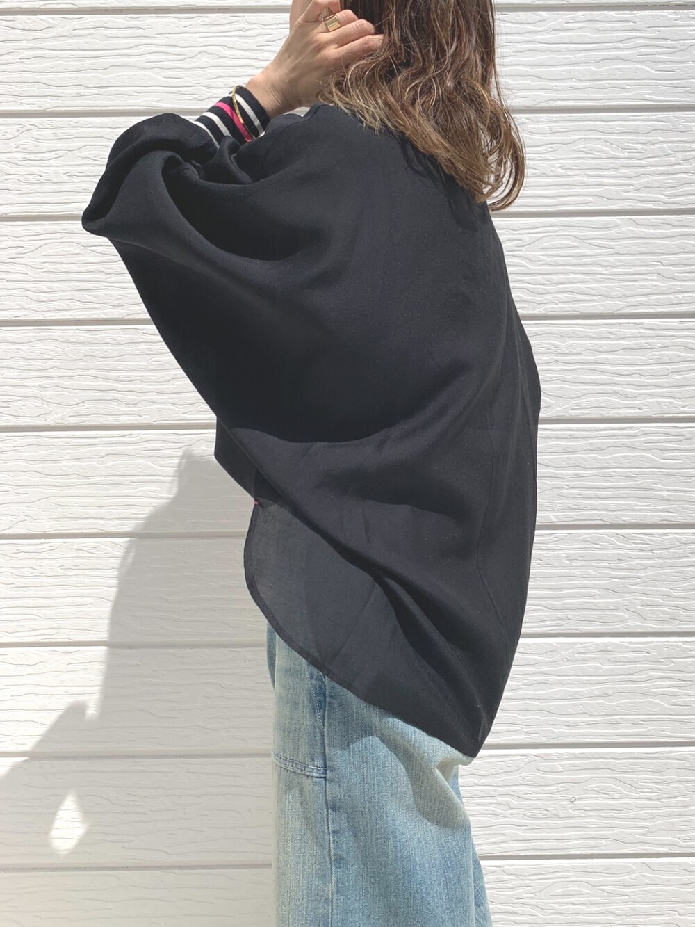 ブルー系のデニムパンツ、ピンク系のショルダーバッグ、ブラック系のシャツ/ブラウスを着用したレディースの春コーディネートの4枚目の写真