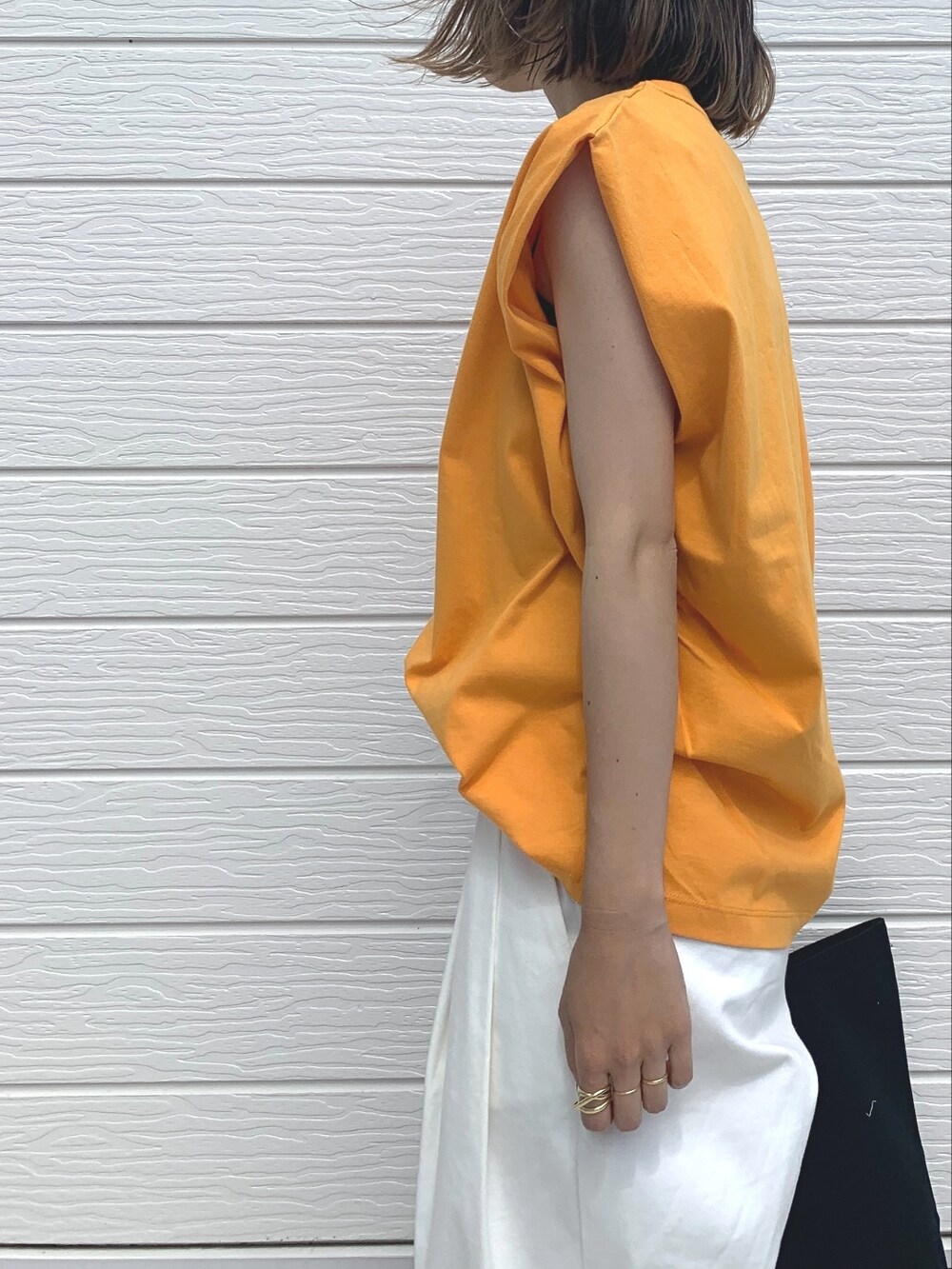 ブラック系のトートバッグ、ホワイト系のその他パンツ、ブラック系のサンダルを着用したレディースの夏コーディネートの3枚目の写真