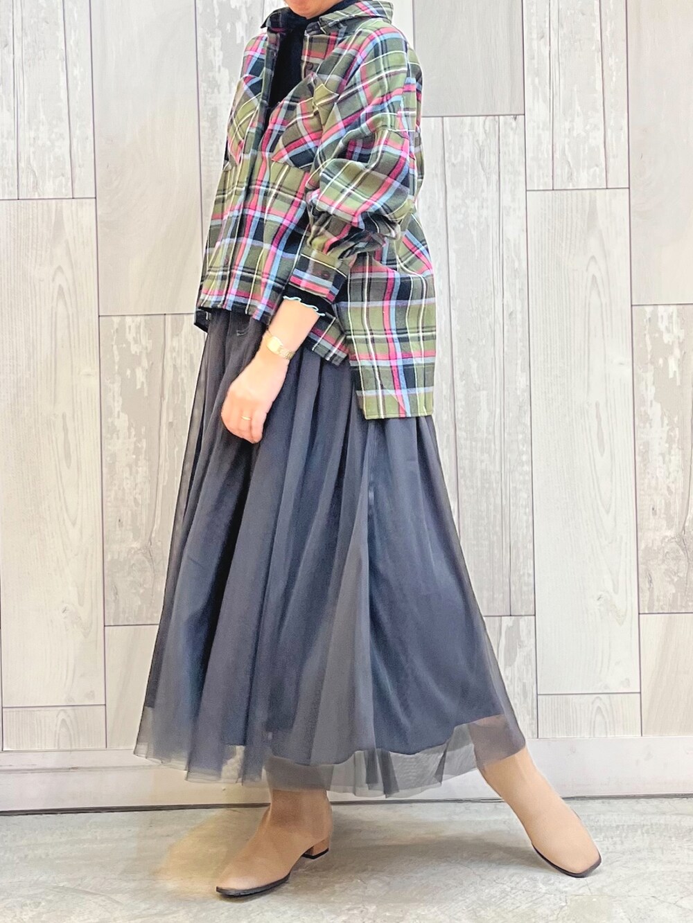 ベージュ系のブーツ、グリーン系のシャツ/ブラウス、ブラック系のスカートを着用したレディースの秋コーディネートの2枚目の写真