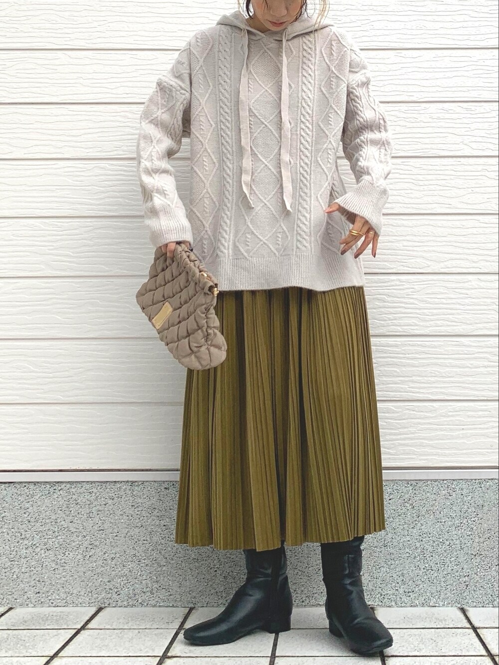 ブラック系のブーツ、ベージュ系のショルダーバッグ、ホワイト系のニット/セーターを着用したレディースの冬コーディネートの2枚目の写真