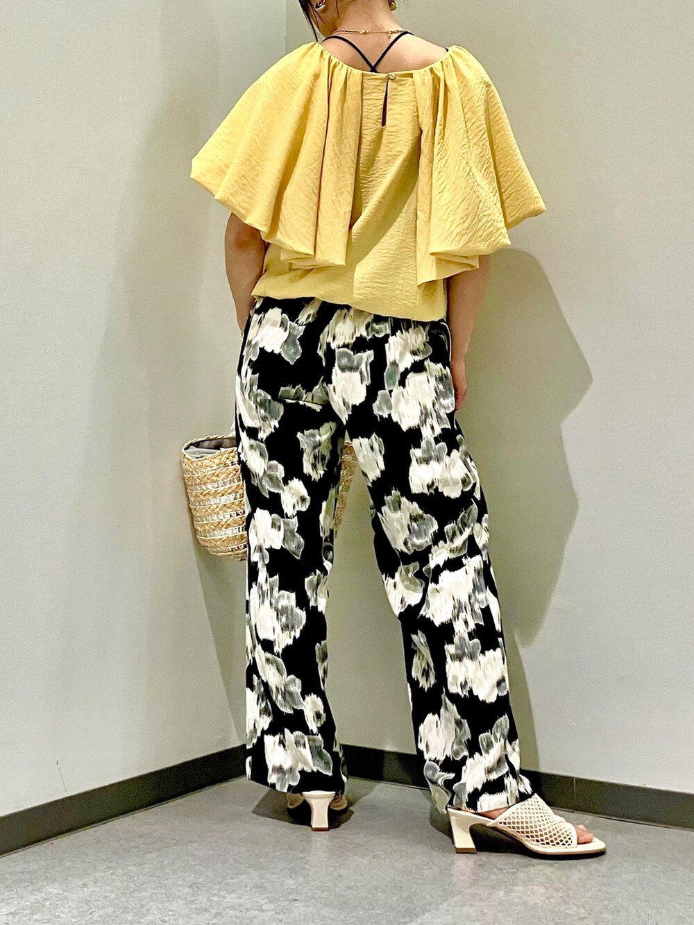 イエロー系のシャツ/ブラウス、シルバー系のかごバッグ、ブラック系のその他パンツを着用したレディースの夏コーディネートの3枚目の写真