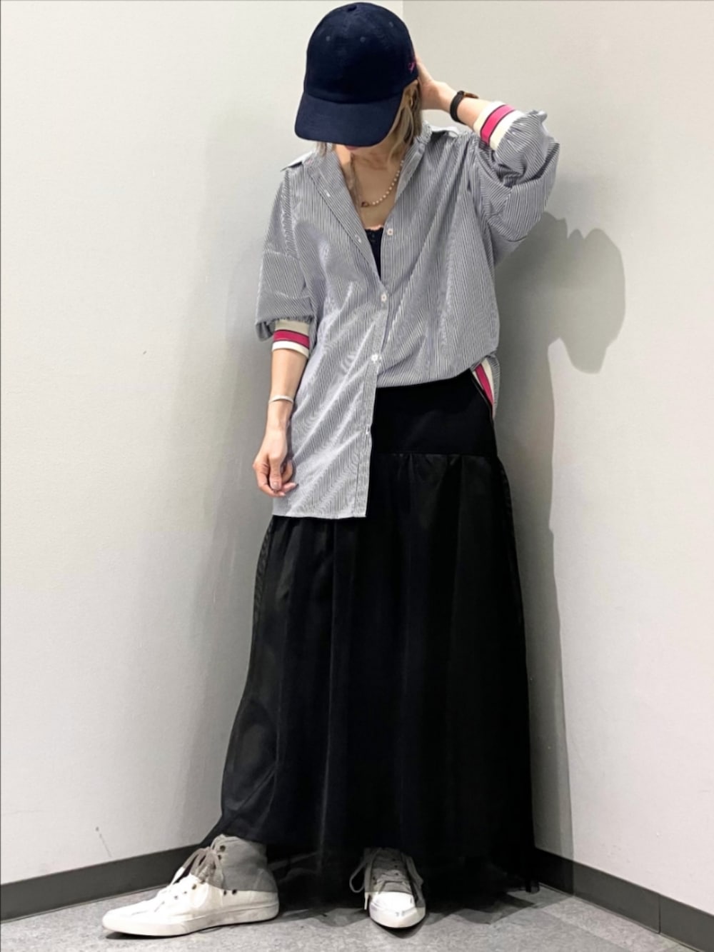 ブラック系のスカート、ブルー系のシャツ/ブラウス、ブルー系のキャップを着用したレディースの春コーディネートの2枚目の写真