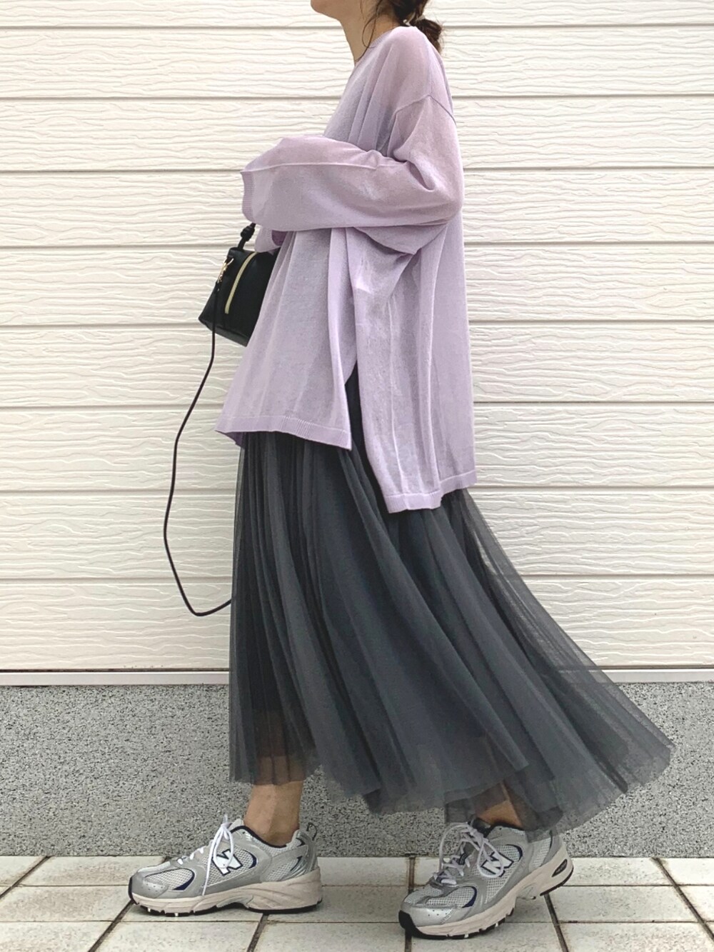 シルバー系のスニーカー、パープル系のニット/セーター、ブラック系のハンドバッグを着用したレディースの春コーディネートの2枚目の写真