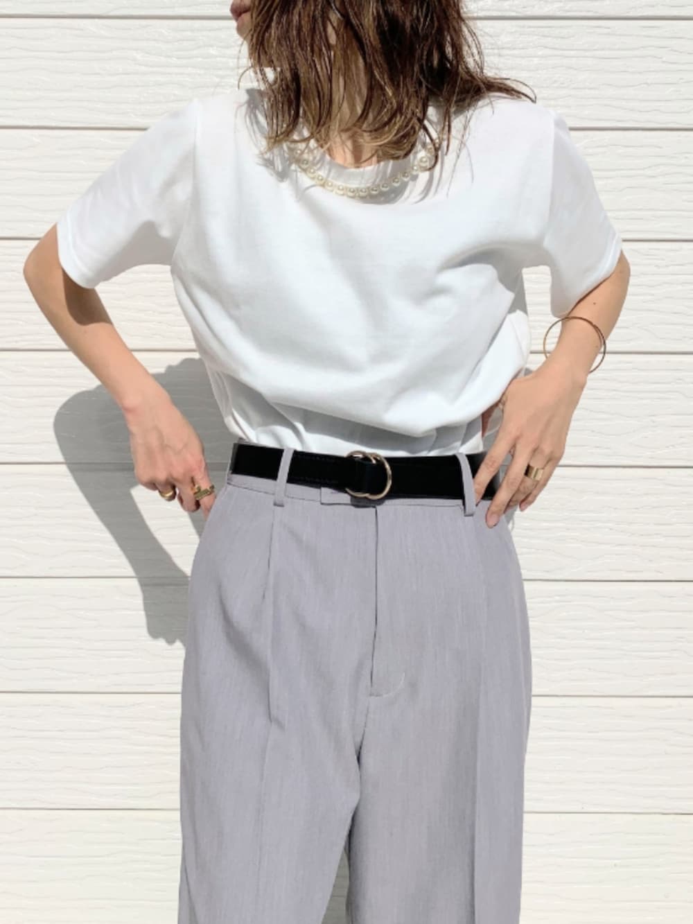 グレー系のその他パンツ、ホワイト系のTシャツ/カットソー、シルバー系のハンドバッグを着用したレディースの春コーディネートの3枚目の写真