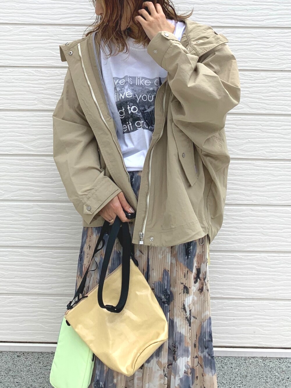 イエロー系のスカート、ホワイト系のスニーカー、ベージュ系のショルダーバッグを着用したレディースの春コーディネートの3枚目の写真