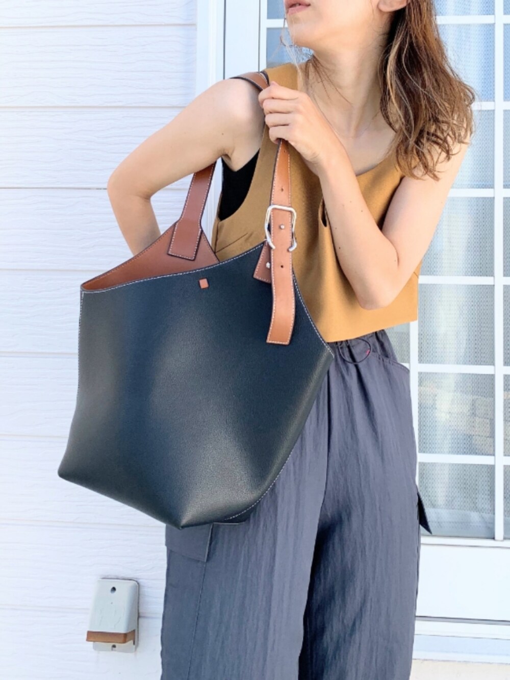 グレー系のその他パンツ、イエロー系のベスト、ブラック系のショルダーバッグを着用したレディースの夏コーディネートの5枚目の写真