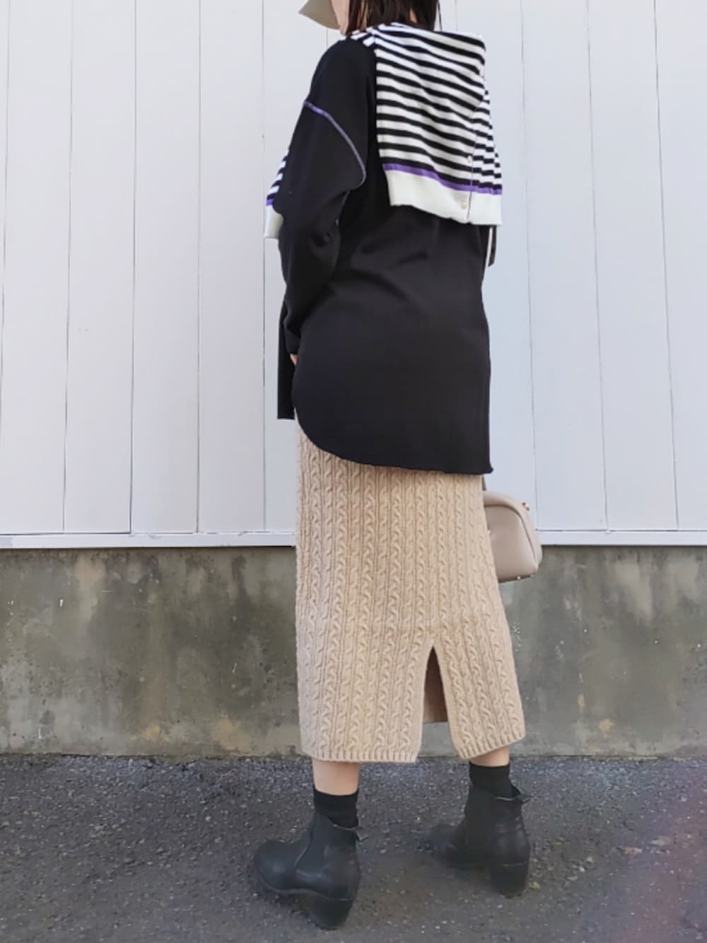 ホワイト系のボストンバッグ、ベージュ系のスカート、ブラック系のTシャツ/カットソーを着用したレディースの冬コーディネートの4枚目の写真
