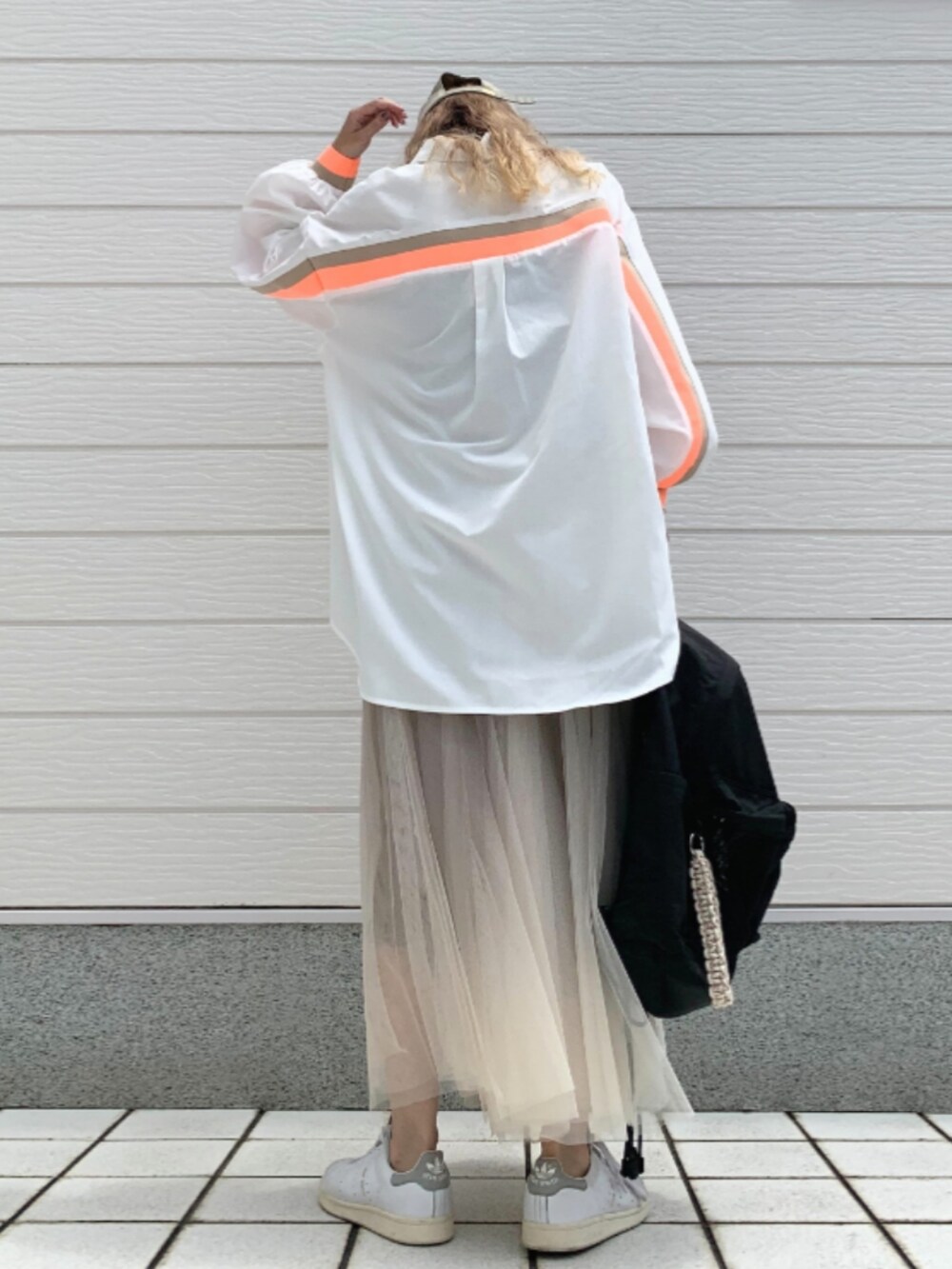 ゴールド系のスカート、ホワイト系のスニーカー、ブラック系のバックパック/リュックを着用したレディースの夏コーディネートの3枚目の写真