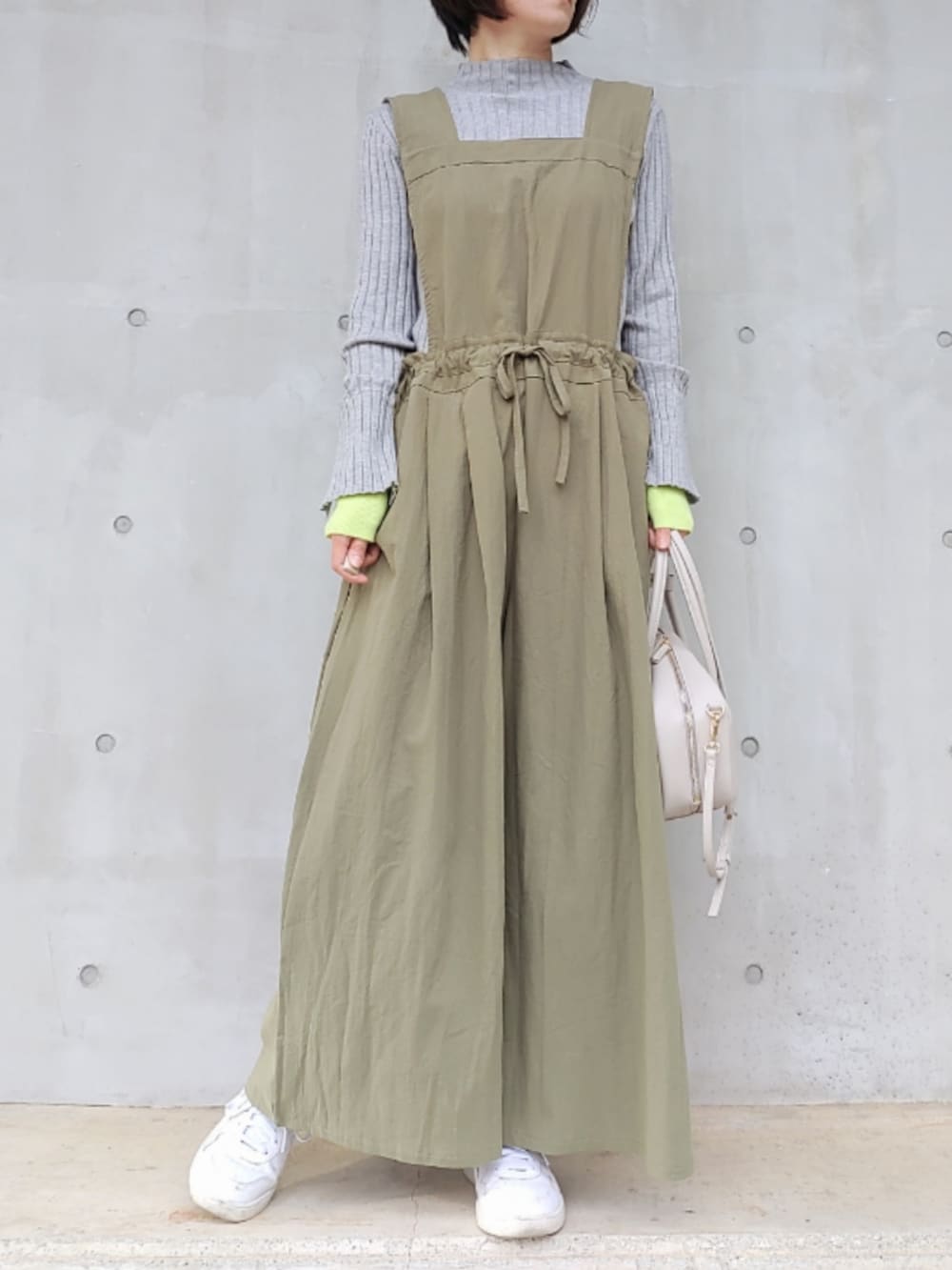 ホワイト系のボストンバッグ、ホワイト系のスニーカー、グレー系のニット/セーターを着用したレディースの冬コーディネートの2枚目の写真