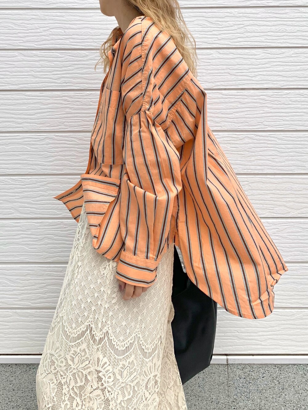 オレンジ系のシャツ/ブラウス、ホワイト系のその他パンツ、ブラック系のトートバッグを着用したレディースの夏コーディネートの4枚目の写真