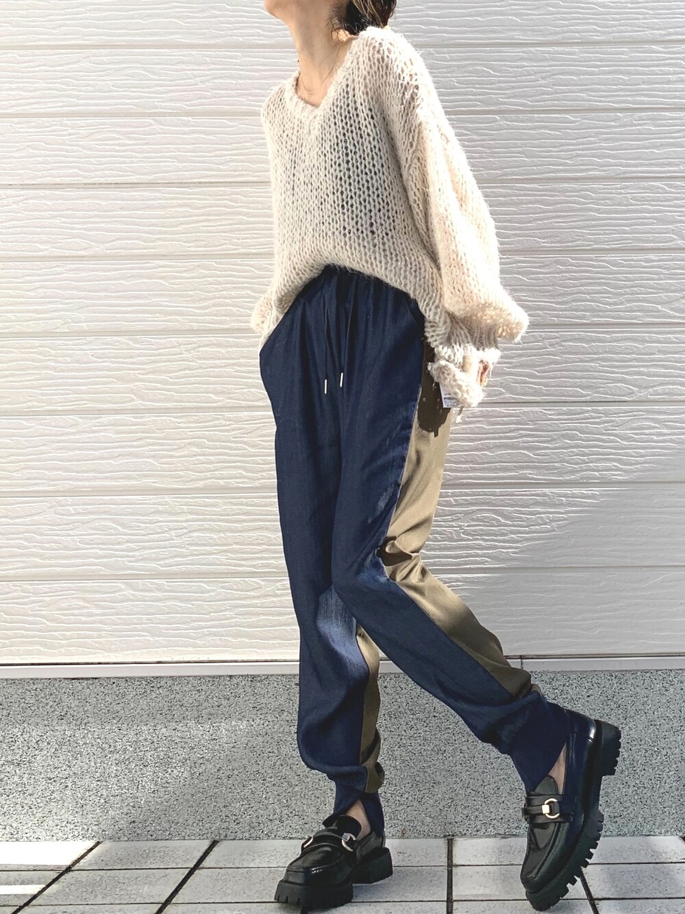 ブラック系のローファー、ホワイト系のニット/セーター、ブラック系のキャミソールを着用したレディースの冬コーディネートの2枚目の写真