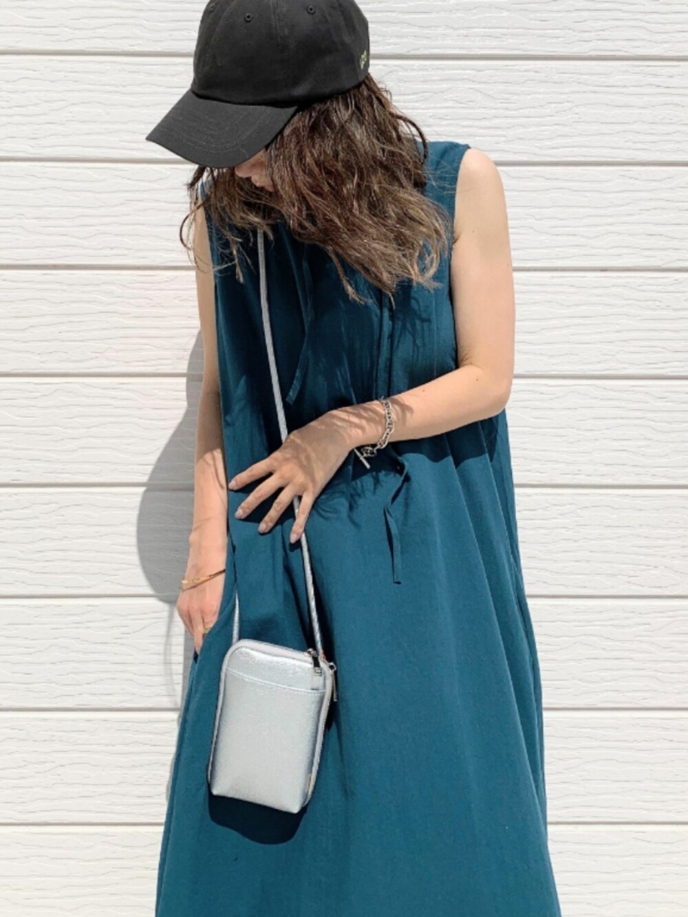 グリーン系のワンピース、グレー系のキャップを着用したレディースの夏コーディネートの4枚目の写真