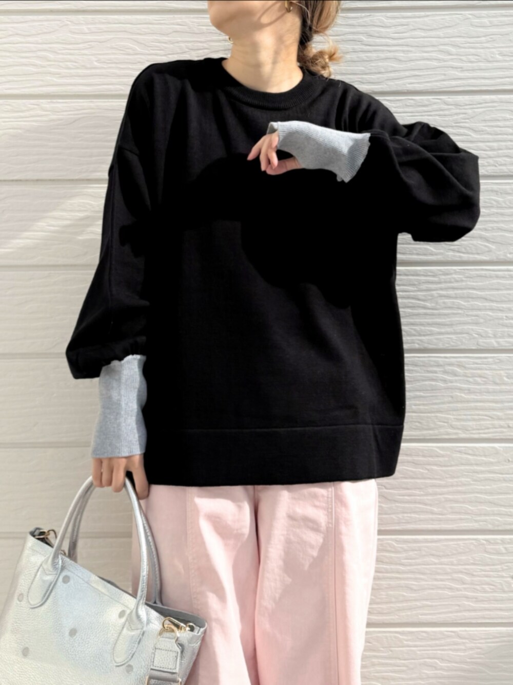 シルバー系のトートバッグ、ピンク系のデニムパンツ、ブラック系のニット/セーターを着用したレディースの冬コーディネートの4枚目の写真