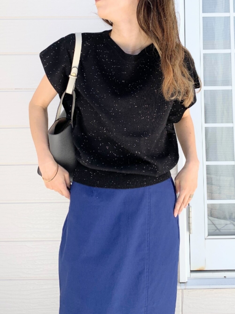 ブルー系のスカート、ブラック系のローファー、グレー系のトートバッグを着用したレディースの春コーディネートの4枚目の写真