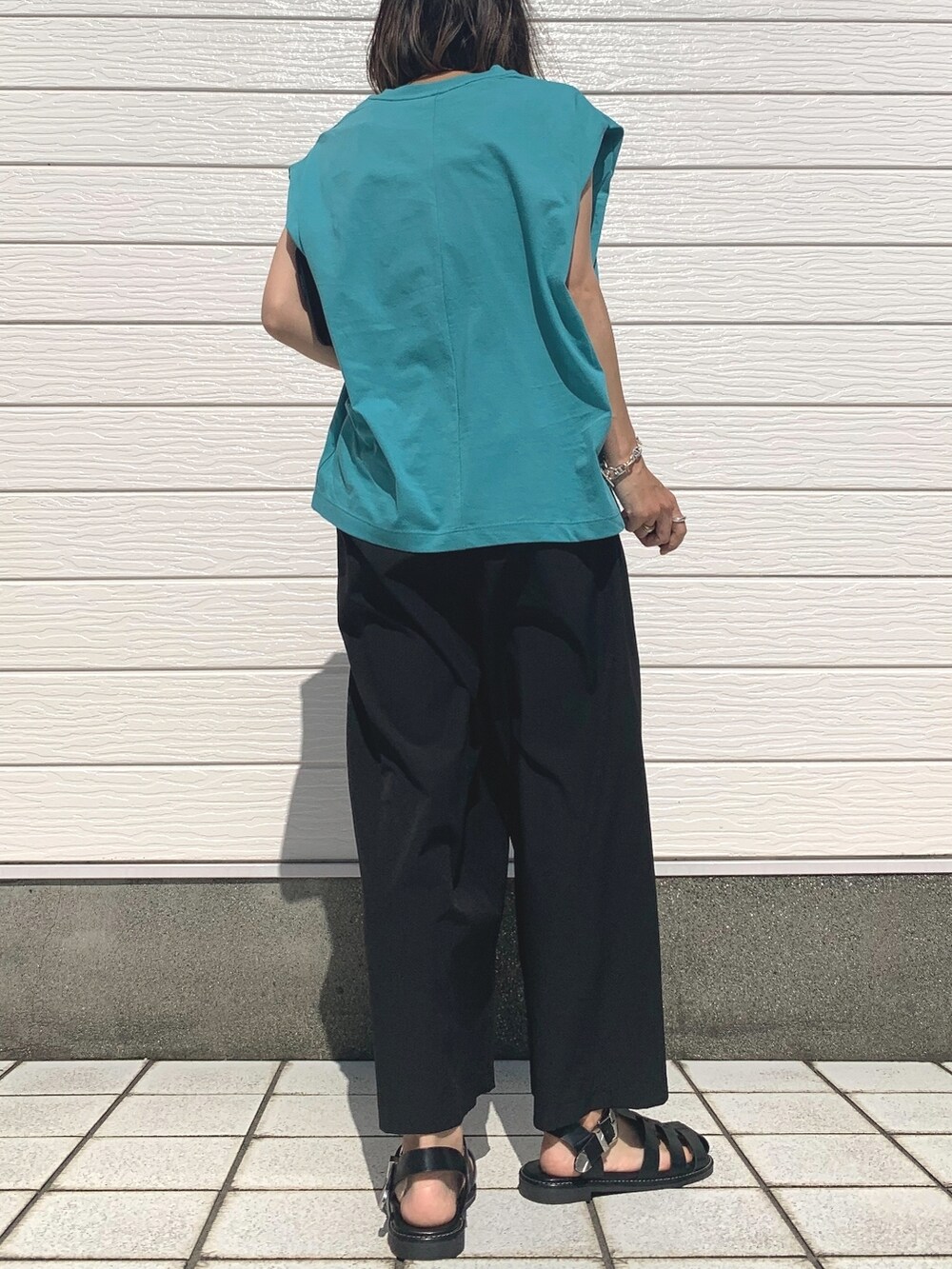 ブラック系のサンダル、ブラック系のその他パンツ、グリーン系のTシャツ/カットソーを着用したレディースの夏コーディネートの2枚目の写真
