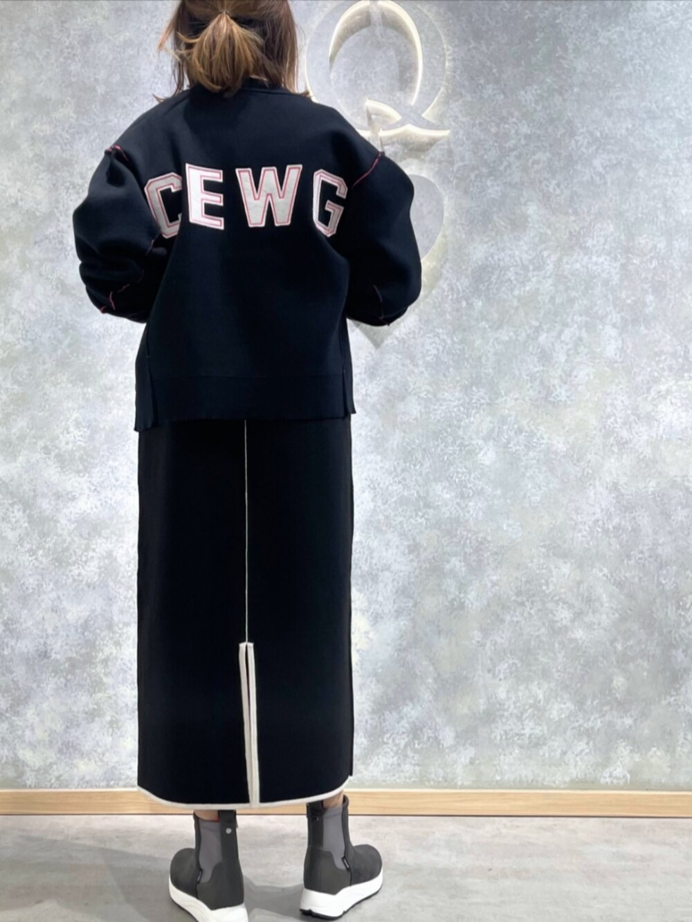 グレー系のブーツ、ブラック系のブルゾン、ブラック系のワンピースを着用したレディースの秋コーディネートの3枚目の写真