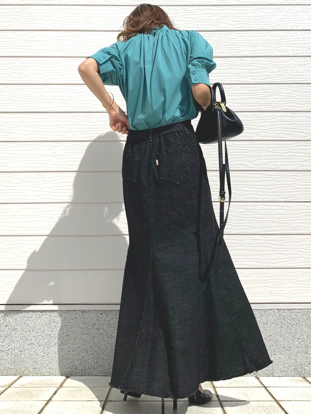 グリーン系のシャツ/ブラウス、ブラック系のデニムスカート、ブラック系のショルダーバッグを着用したレディースの春コーディネートの3枚目の写真