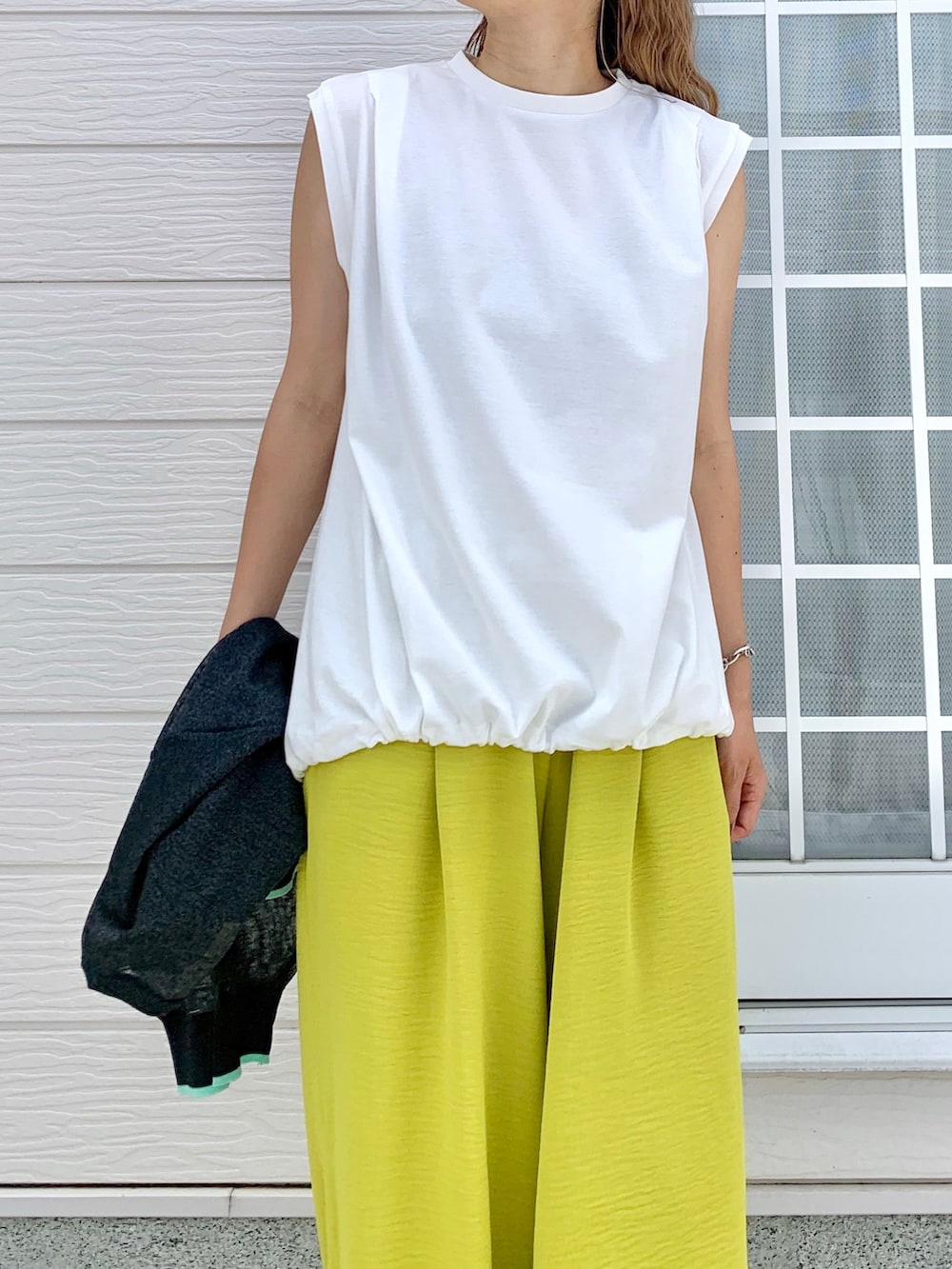 ホワイト系のTシャツ/カットソー、イエロー系のその他パンツ、ブラック系のカーディガン/ボレロを着用したレディースの夏コーディネートの3枚目の写真