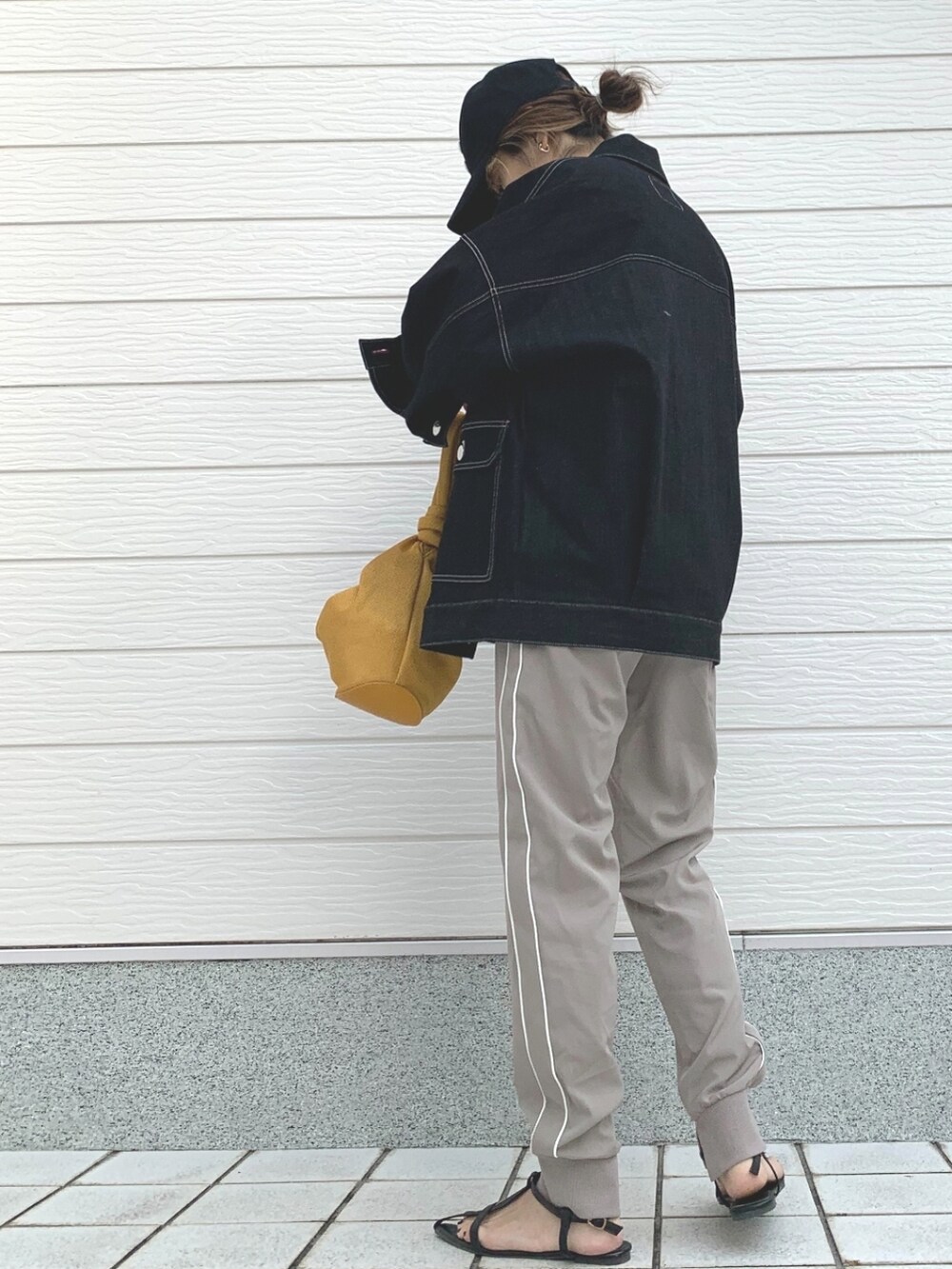 ブラック系のデニムジャケット、ホワイト系のTシャツ/カットソー、イエロー系のショルダーバッグを着用したレディースの冬コーディネートの3枚目の写真