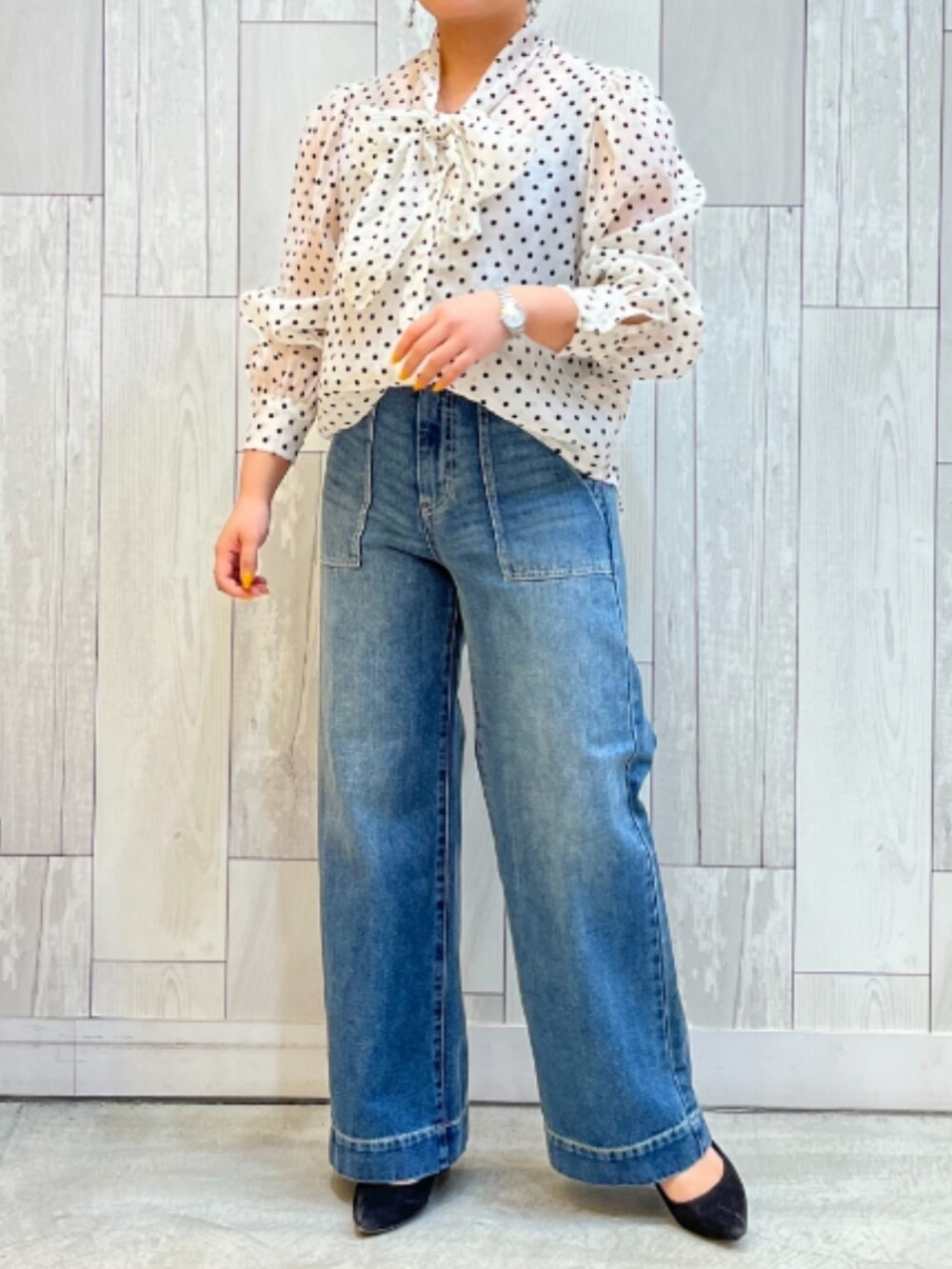 ブルー系のデニムパンツ、ブラック系のノーカラージャケット、ベージュ系のシャツ/ブラウスを着用したレディースの春コーディネートの2枚目の写真