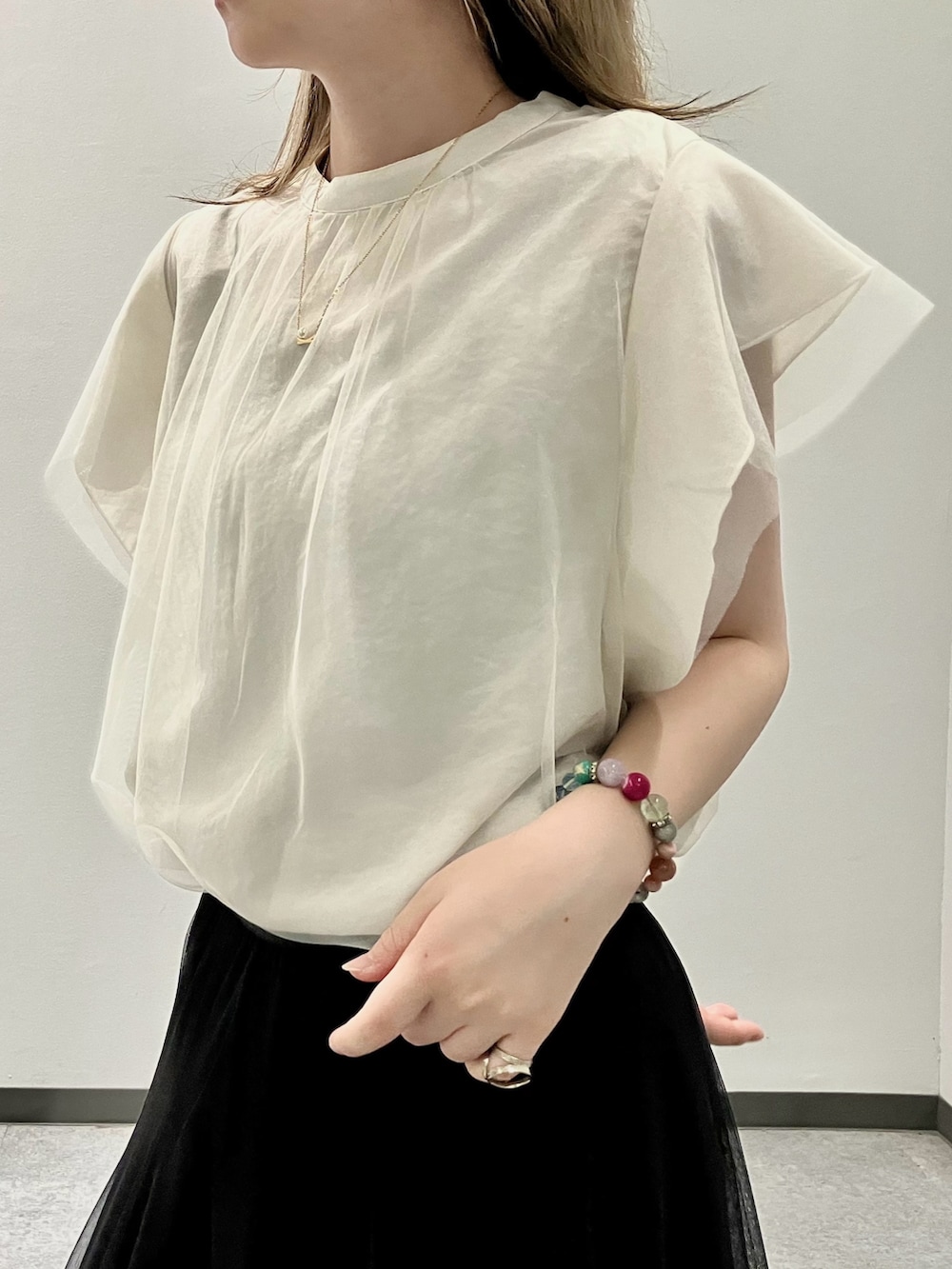 ホワイト系のシャツ/ブラウス、ブラック系のスカート、グレー系のトートバッグを着用したレディースの夏コーディネートの2枚目の写真