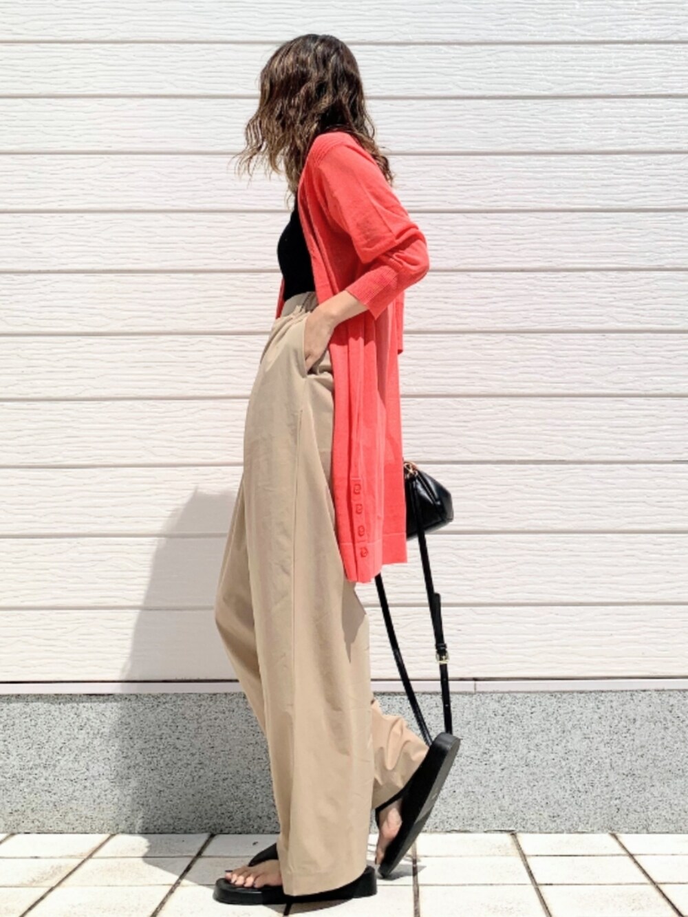 ベージュ系のその他パンツ、ブラック系のショルダーバッグ、オレンジ系のカーディガン/ボレロを着用したレディースの春コーディネートの3枚目の写真