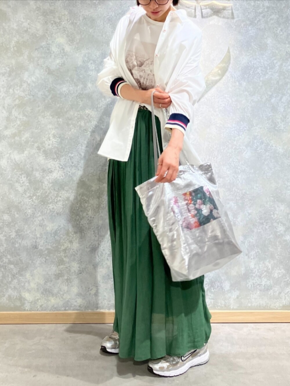 シルバー系のトートバッグ、グリーン系のスカート、ホワイト系のTシャツ/カットソーを着用したレディースの秋コーディネートの2枚目の写真