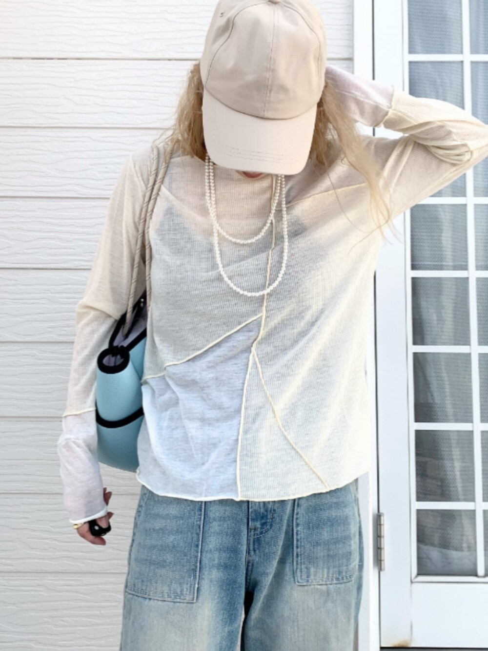 ブルー系のデニムパンツ、ブルー系のトートバッグ、ベージュ系のTシャツ/カットソーを着用したレディースの春コーディネートの3枚目の写真