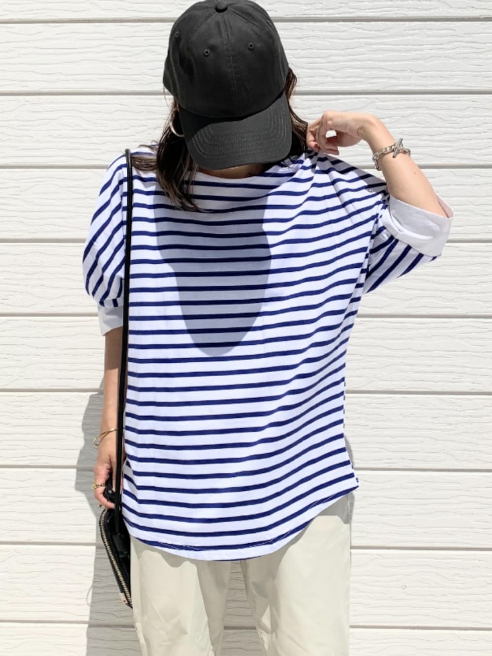 ホワイト系のその他パンツ、ブルー系のTシャツ/カットソー、ブラック系のショルダーバッグを着用したレディースの春コーディネートの3枚目の写真