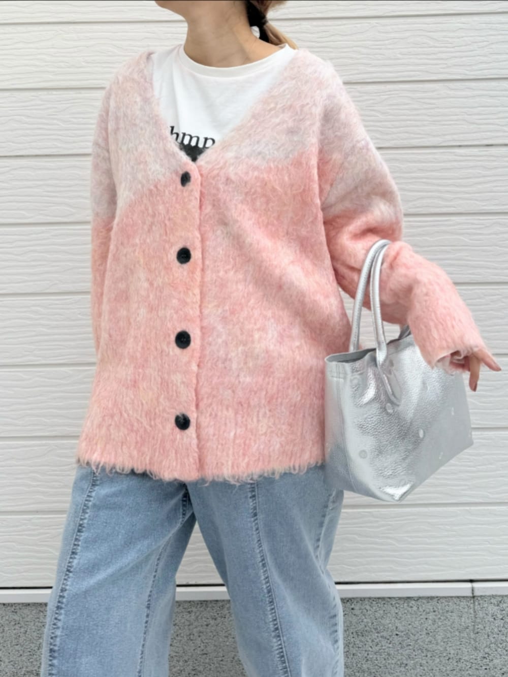 シルバー系のトートバッグ、ホワイト系のTシャツ/カットソー、ブルー系のデニムパンツを着用したレディースの冬コーディネートの4枚目の写真