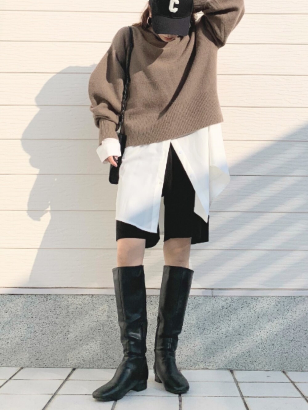 ブラウン系のニット/セーター、ホワイト系のシャツ/ブラウス、グレー系のその他パンツを着用したレディースの冬コーディネートの2枚目の写真