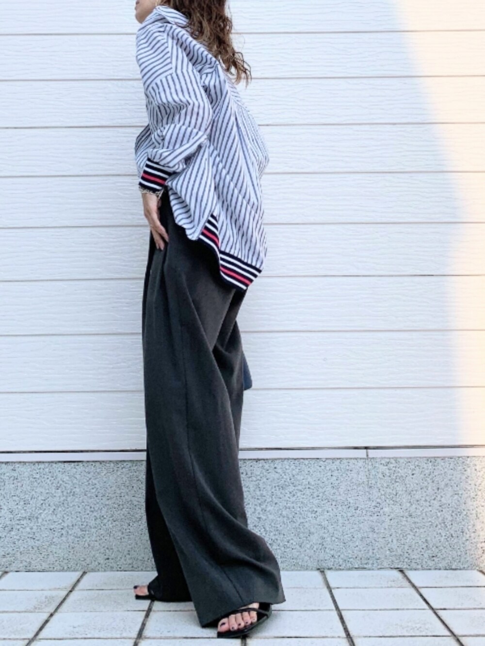 ブルー系のハンドバッグ、ブルー系のシャツ/ブラウス、ブラック系のキャミソールを着用したレディースの夏コーディネートの3枚目の写真