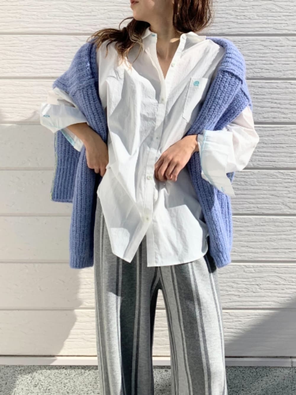 ブルー系のニット/セーター、ブラック系のスニーカー、グレー系のその他パンツを着用したレディースの冬コーディネートの4枚目の写真