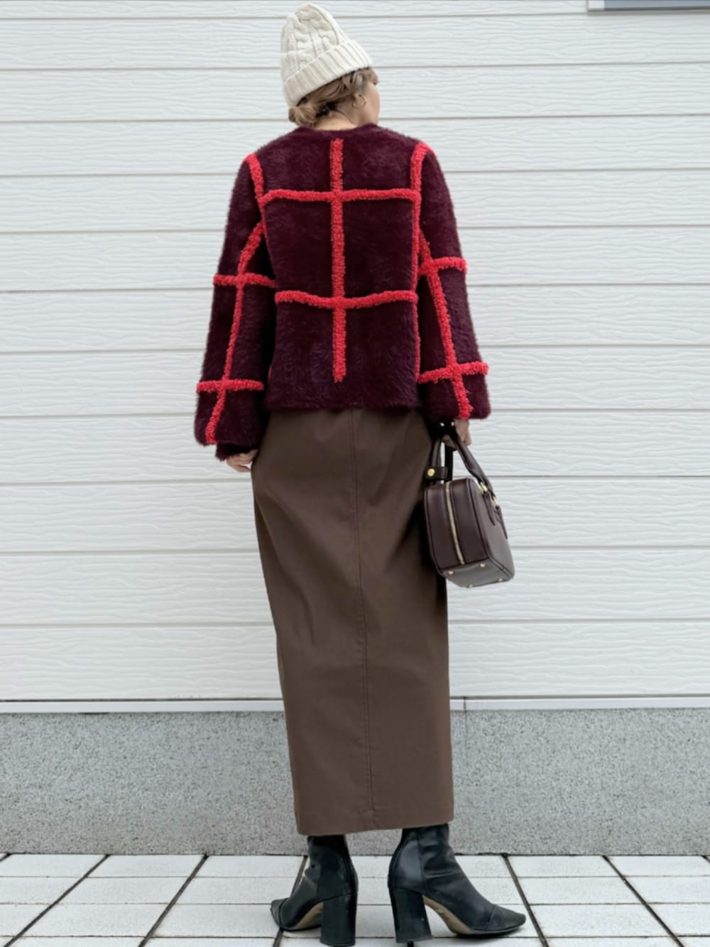 ブラウン系のスカート、ホワイト系のニットキャップ/ビーニーを着用したレディースの秋コーディネートの3枚目の写真