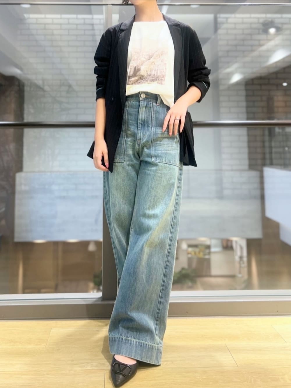 ブルー系のデニムパンツ、ホワイト系のTシャツ/カットソーを着用したレディースの秋コーディネートの2枚目の写真