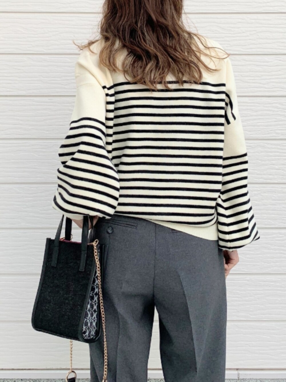 グレー系のその他パンツ、ホワイト系のスニーカー、ブラック系のショルダーバッグを着用したレディースの冬コーディネートの4枚目の写真