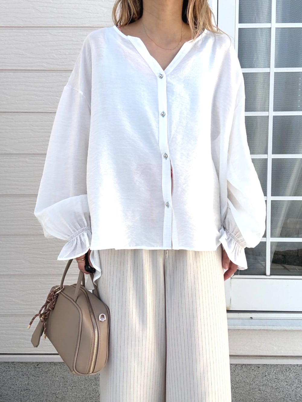 ベージュ系のその他パンツ、ベージュ系のボストンバッグ、ホワイト系のシャツ/ブラウスを着用したレディースの春コーディネートの2枚目の写真